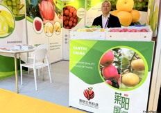 Sales representative of Yalian Biotechnology with a variety of apples and pears on display. The company's main products include Read Fuji apple, Golden Venus apple, Cream Fuji apple, Ya pear and Huangguan pear. / 雅联生物科技销售代表正在展示各种苹果和梨。该公司的主要产品有红富士苹果、Golden Venus 苹果、奶油富士苹果、鸭梨、皇冠梨等。 