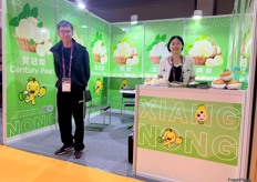 Victor (left) and his colleague of the Xiangnong team on the stand. Based in Xinji, the company grows and exports a wide variety of pears, including the Centruy pear and the Ya pear. Southeast Asia is their main export market. / Victor（左）和他的乡浓团队同事在展台上。该公司总部位于辛集，种植并出口各种梨，包括 Centruy 梨和鸭梨。东南亚是他们的主要出口市场。 