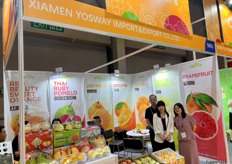 Mrs Liu (first right) and the team of Yosway, a pomelo grower and exporter based in Xiamen, with a product display on the stand. Besides exporting, the company also has a cooperative farm in Thailand and exports a large volume of Thai ruby pomelos to the Chinese market./ 刘女士（右一）与厦门柚子种植及出口商 Yosway 团队在其展位上展示产品。除出口外，该公司还在泰国拥有合作农场，向中国市场出口大量泰国 Ruby 柚。 