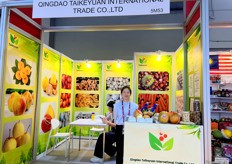 Sales representative from Qingdao Taikeyuan International Trade with product display at the stand. / 青岛泰科源国际贸易有限公司的销售代表在展位上展示产品。