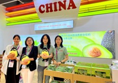 Sabrina (second left) with her colleagues of Mr Avocado, holding their iconic avocado puppet. Avocados are the company's only product. The company imports avocados from around the world for Chinese consumers. / Mr Avocado 展位。Sabrina（左二）和她的同事拿着他们标志性的牛油果木偶。牛油果是该公司的唯一产品。该公司为中国消费者从世界各地进口牛油果。 