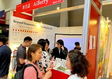 Visitors tasting fresh stawberries at the stand of AiBerry, a vertical farm stawberry grower. / 参观者在垂直农场草莓种植者美吉蔬的展位品尝新鲜草莓。 