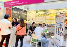 Sales representative of Xi Chong Starway Bio-Technology is talking with visitors at their stand. / 西充星河生物科技有限公司的销售代表在展位上与参观者交谈。 