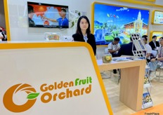 Sales representative at the Golden Fruit Orchard stand. / Golden Fruit Orchard 展位的销售代表。 